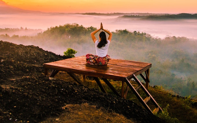 meditating over forested valley